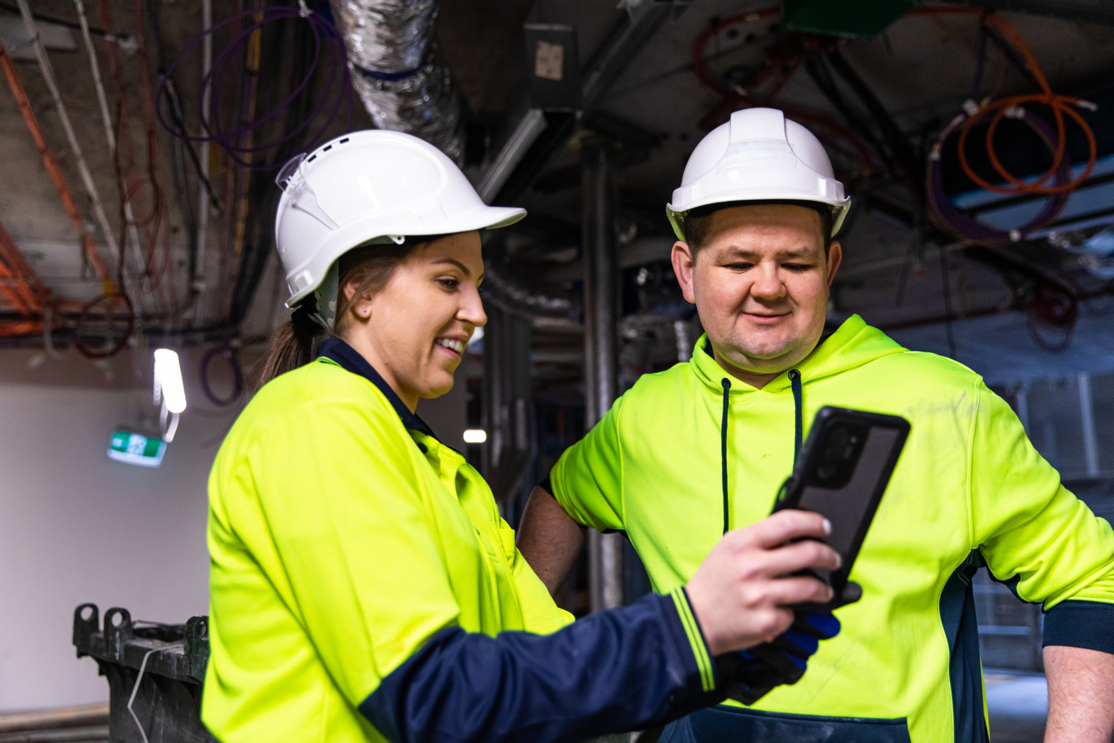 Male and female tradesman standing together looking at a phone